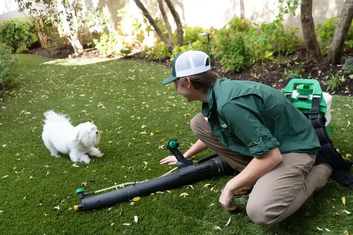 Technician with a small dog on a lawn. Pest Control DFW.