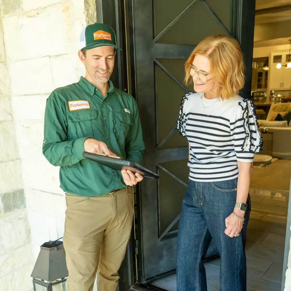 Forterra Pest Control technician talking with a homeowner at her front door
